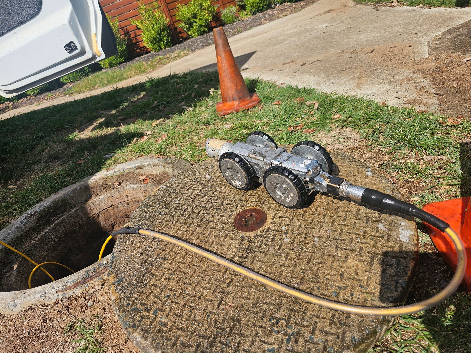 A robotic camera being lowered into an open manhole, used for infrastructure inspection — Pro Pipe Solutions in Queanbeyan, NSW