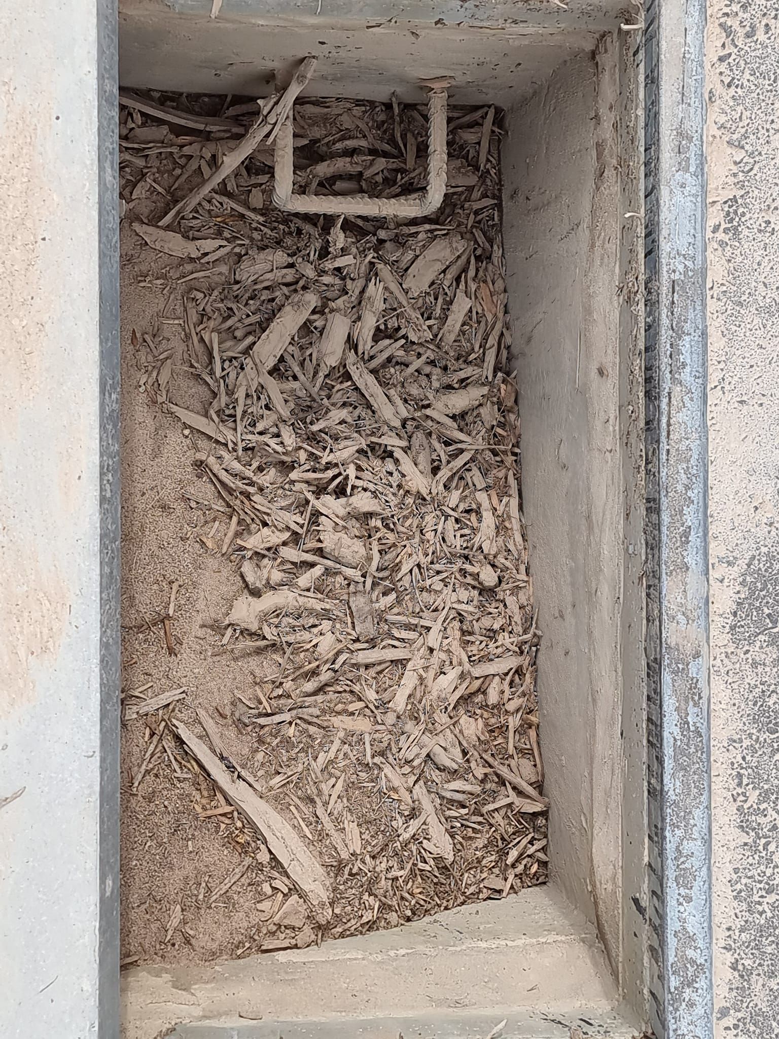 Concrete rectangular basin filled with wood chips and a white pipe — Pro Pipe Solutions in Queanbeyan, NSW