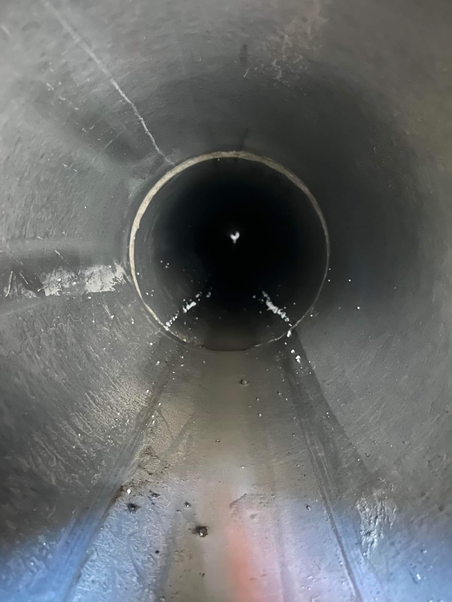 Looking into a dark, cylindrical pipe with visible cracks and specks — Pro Pipe Solutions in Queanbeyan, NSW