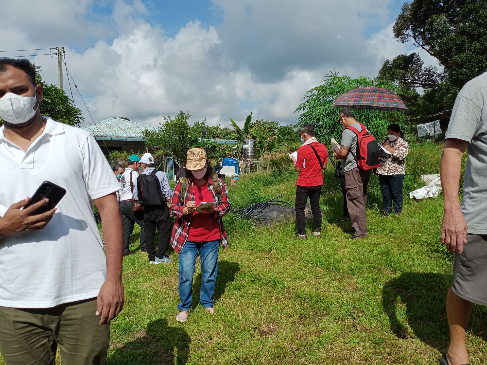 Priest handing document to a man in a church during a ceremony. Others hold papers and watch.
