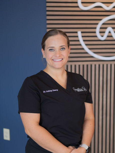 Dr. Deacy posing for a photo in black scrubs 