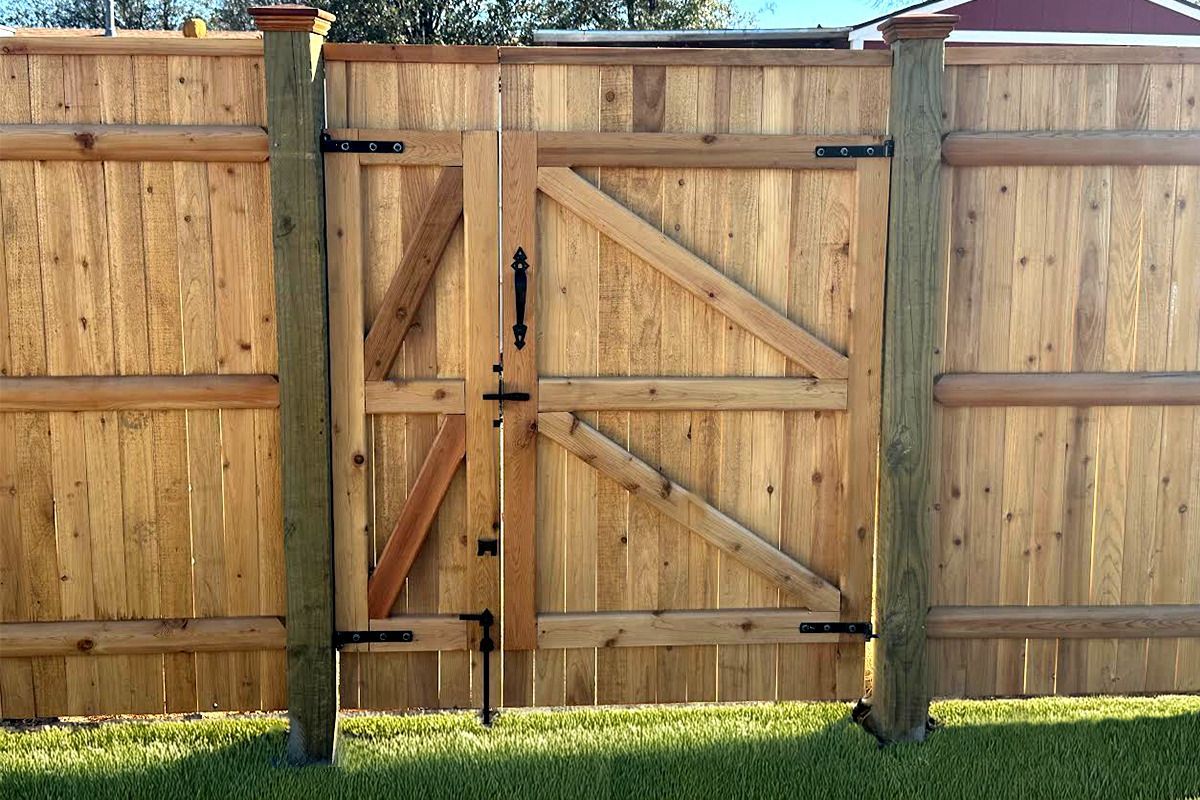 A wooden fence with a gate in the middle of it.
