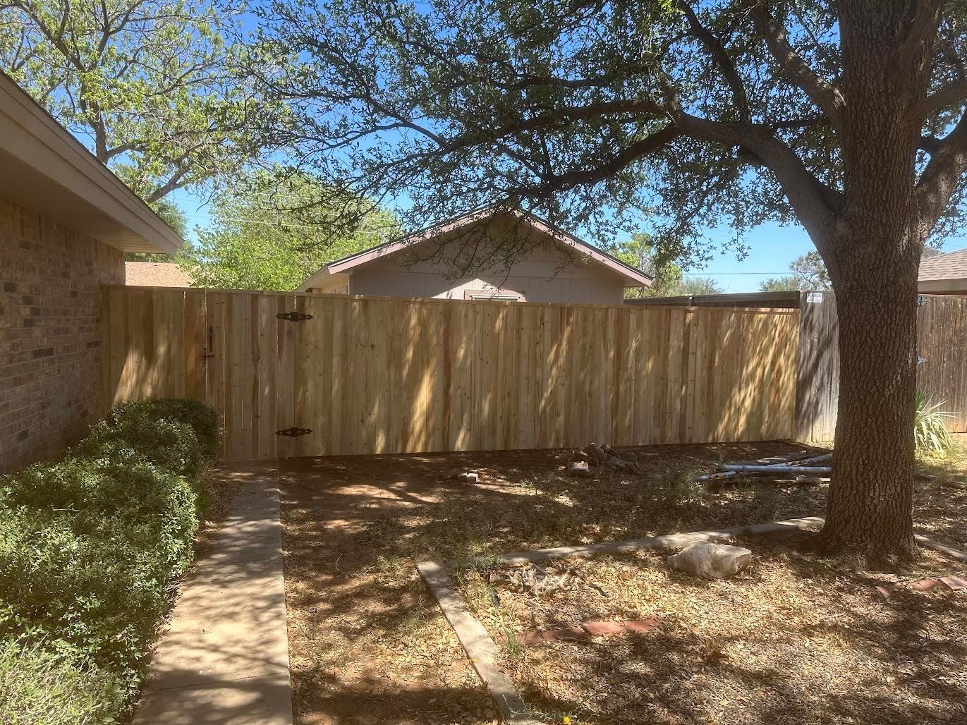 There is a wooden fence in the backyard of a house.