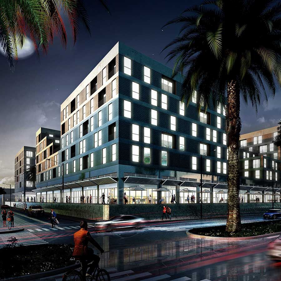 Un hombre anda en bicicleta frente a un gran edificio por la noche.