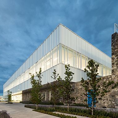 Un edificio grande con muchas ventanas y árboles frente a él.