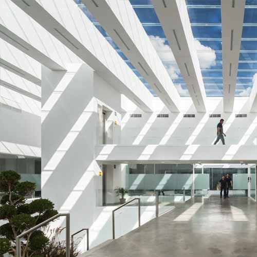 Un par de personas caminando en un edificio con un tragaluz.