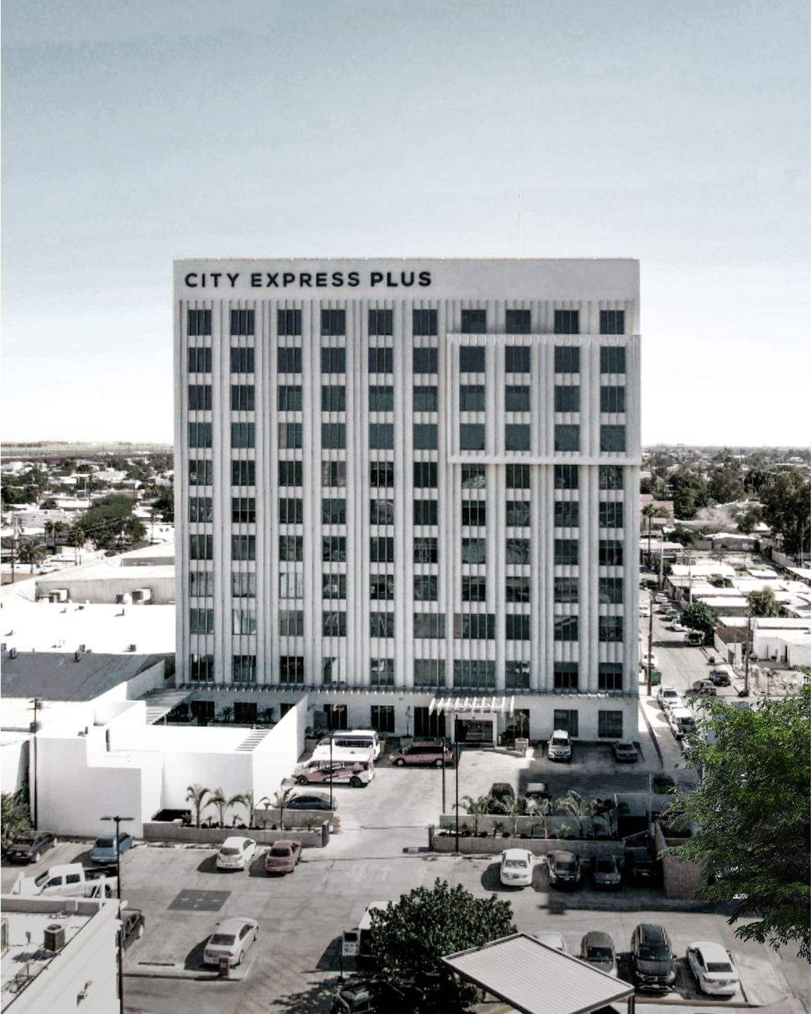 Un edificio City Express Plus con coches aparcados delante.