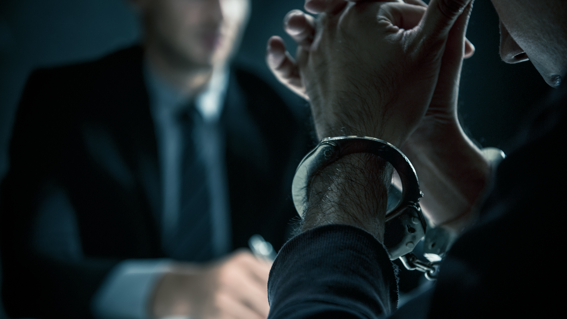 Person holding scales of justice, gavel on table, legal setting.