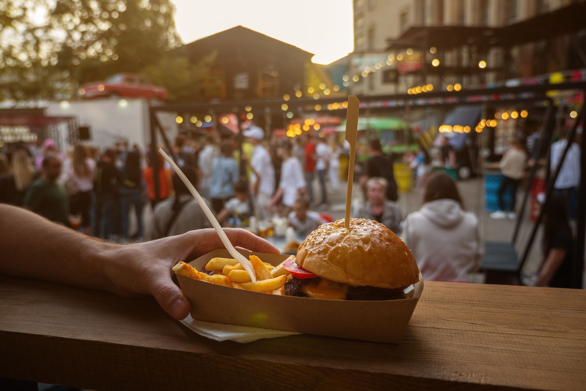 A person holding a tray with a burger and fries 