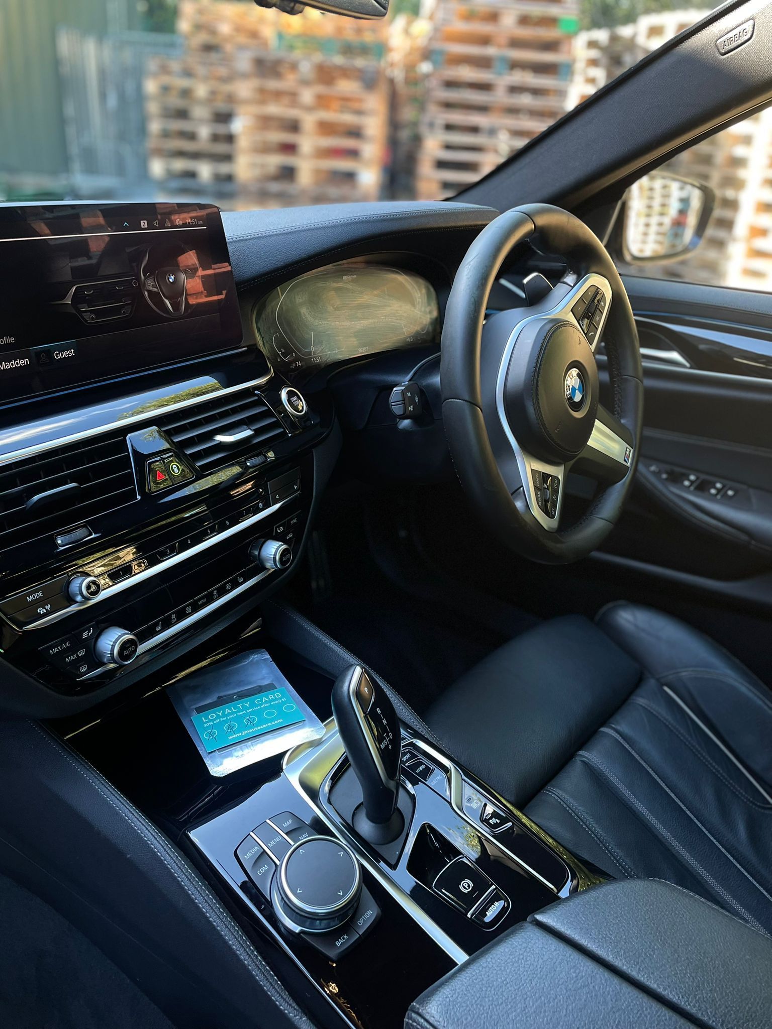 Interior of a black BMW car with dashboard, steering wheel, and console visible.