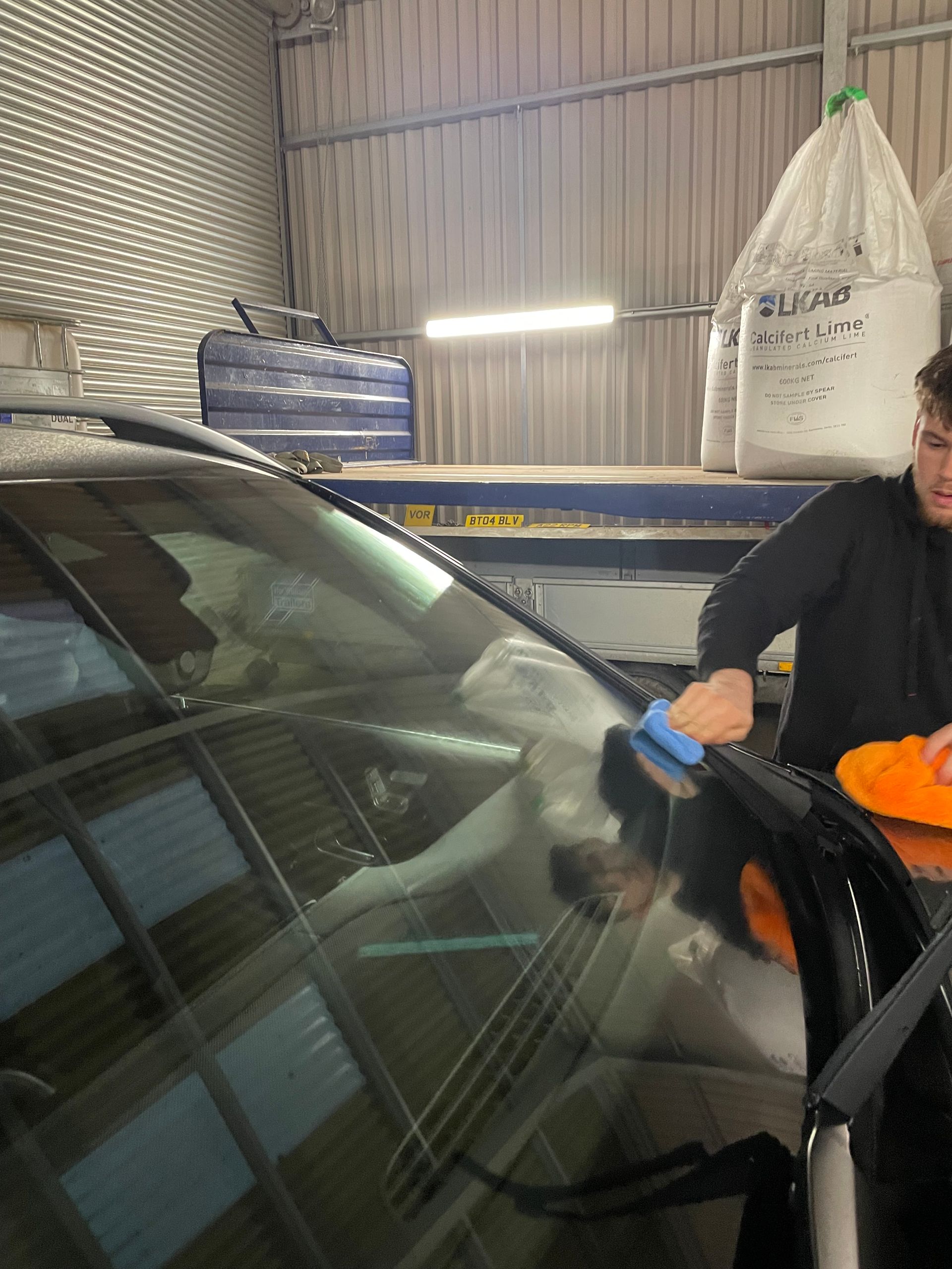 professional detailer applying ceramic coating to luxury car windscreen in south wales
