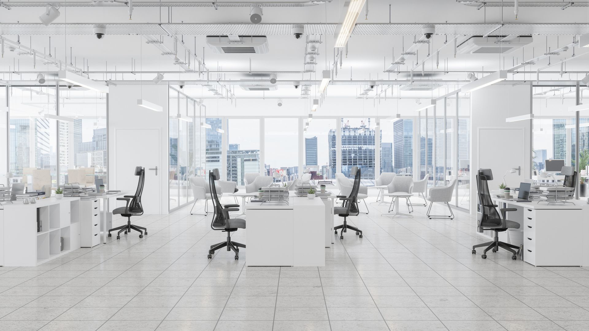 A bright, modern, minimalist office space with white desks, ergonomic chairs, and large windows overlooking a city.