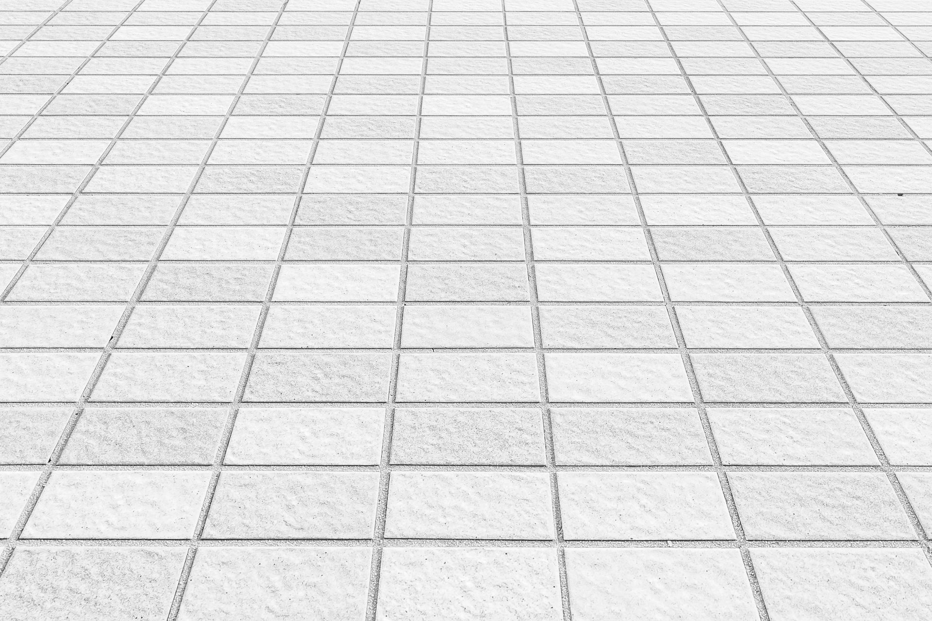 White rectangular subway tiles on two walls meeting at a corner with dark grout lines. White rectangular subway tiles on two walls meeting at a corner with dark grout lines.