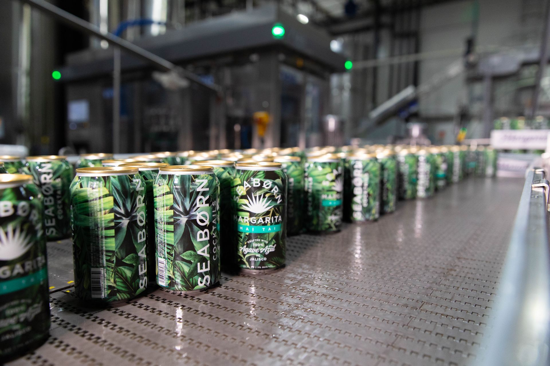 a conveyor belt filled with cans of beer in a factory .