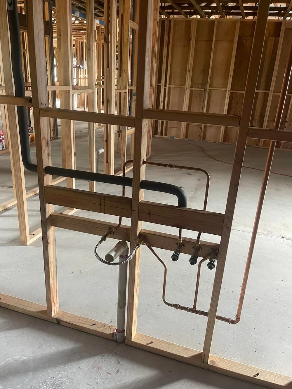 Wooden Frame With Plumbing Pipes in a New Construction Building — D & B Plumbing NQ in Trinity Beach, QLD