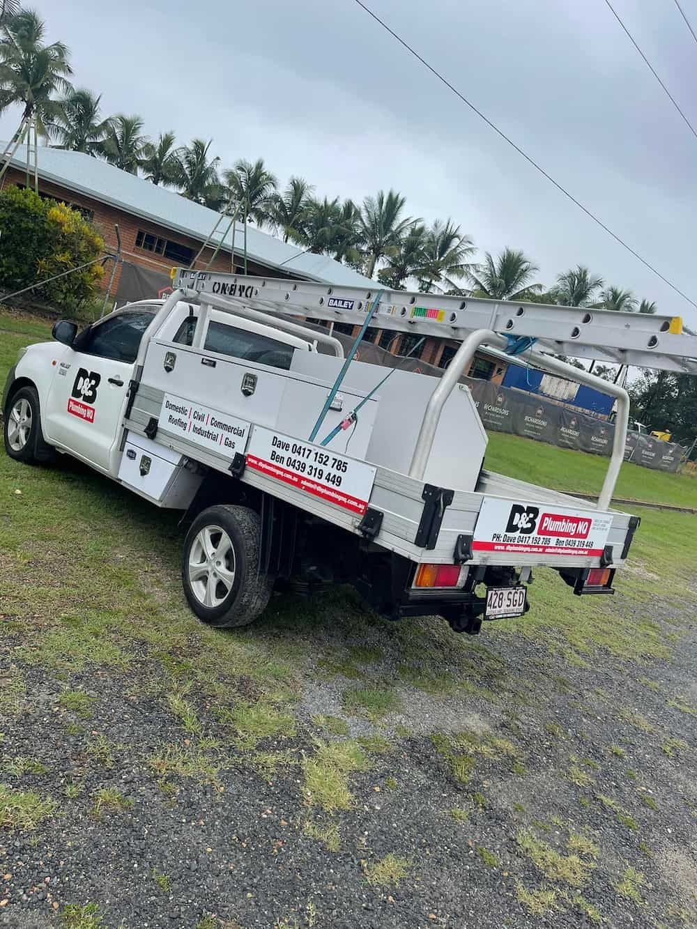 White Utility Truck on Grass With a Ladder Rack, Parked Near a Building — D & B Plumbing NQ in Trinity Beach, QLD