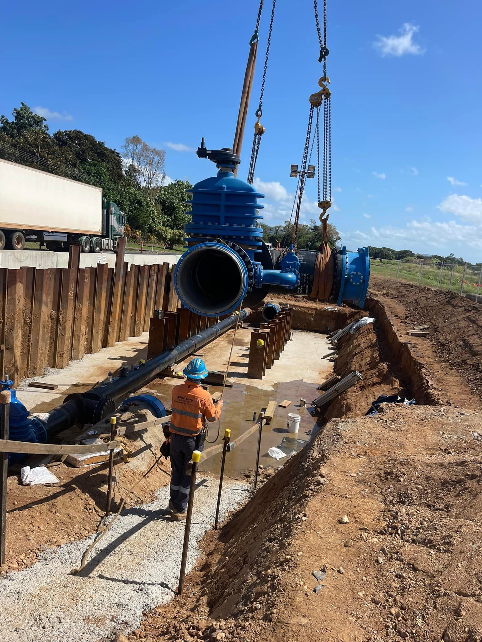A Plumber in a Blue Uniform and Cap Repairs a Sink's Pipes — D & B Plumbing NQ in Redlynch, QLD