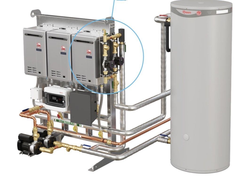 Close-up of a commercial water heating system. Includes a tank and multiple heater units with pipes and controls.