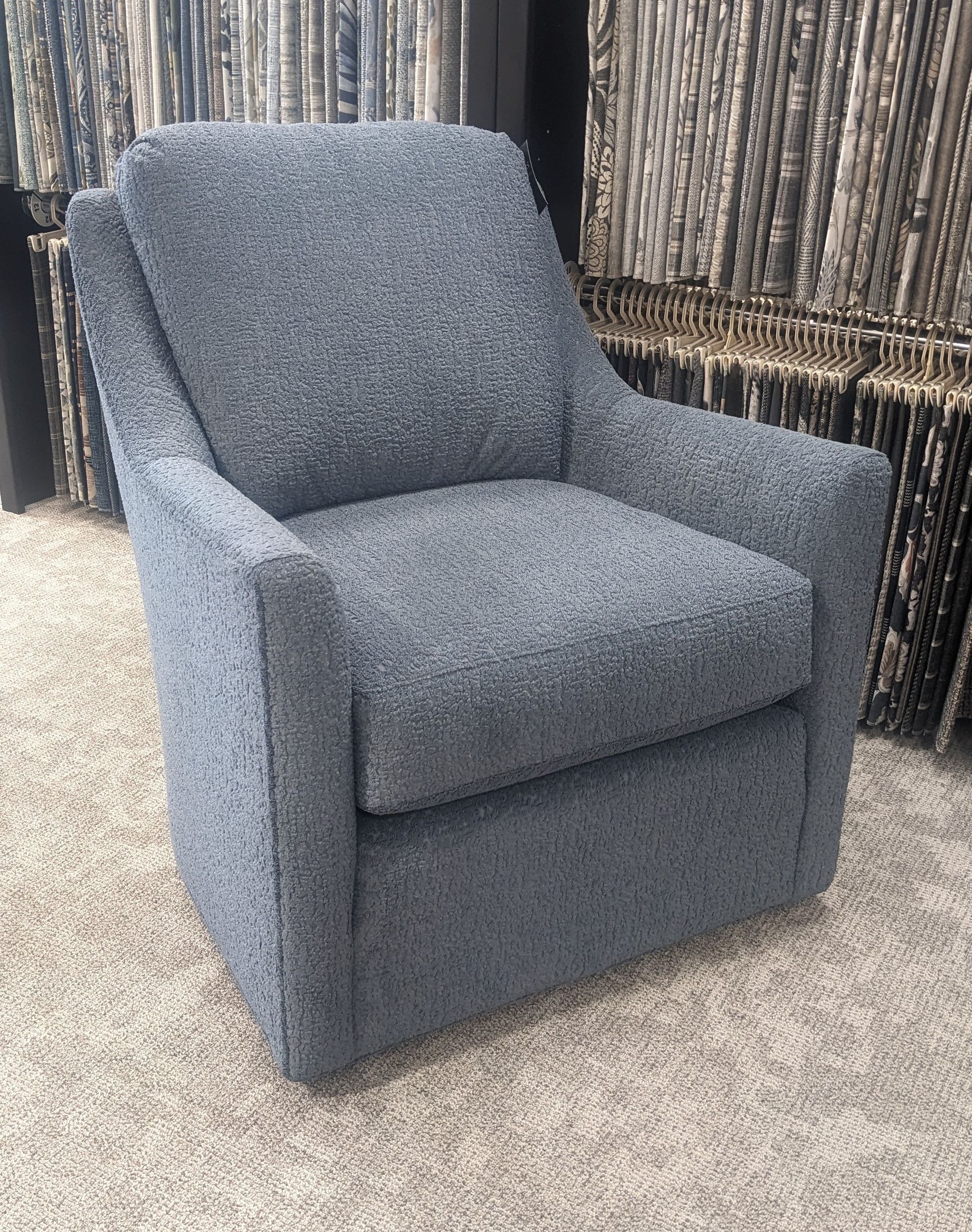 A blue chair is sitting on a carpet in a room.