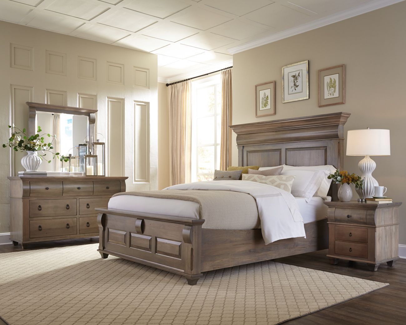 A bedroom with a bed , dresser , nightstand , mirror and rug.