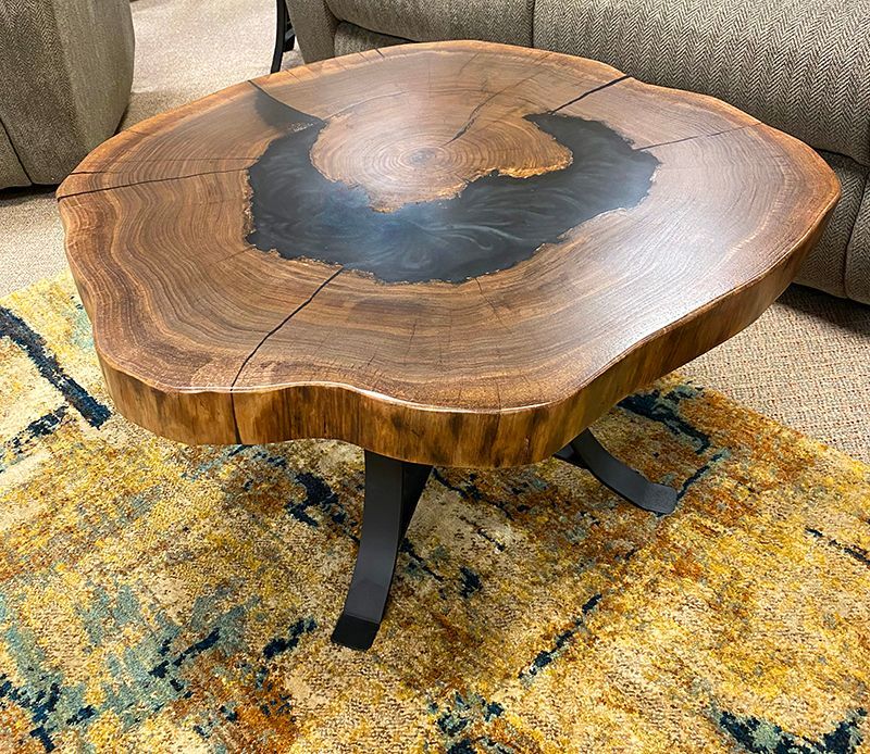 A wooden coffee table is sitting on a rug in a living room.