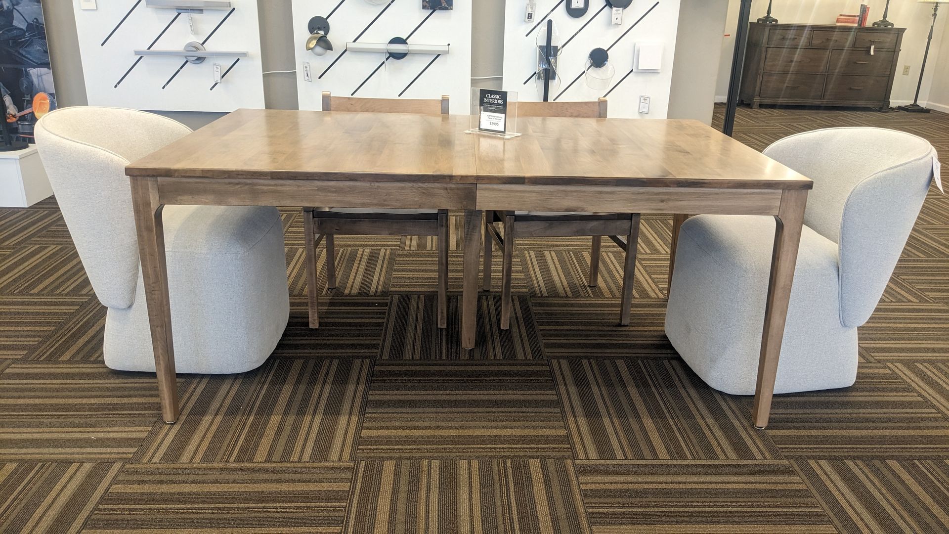 A table and chairs are sitting on a carpeted floor in a room.