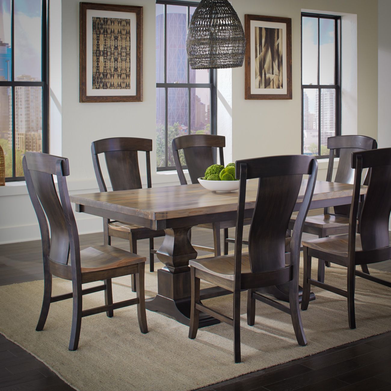 A dining room table and chairs with a bowl of green apples on it