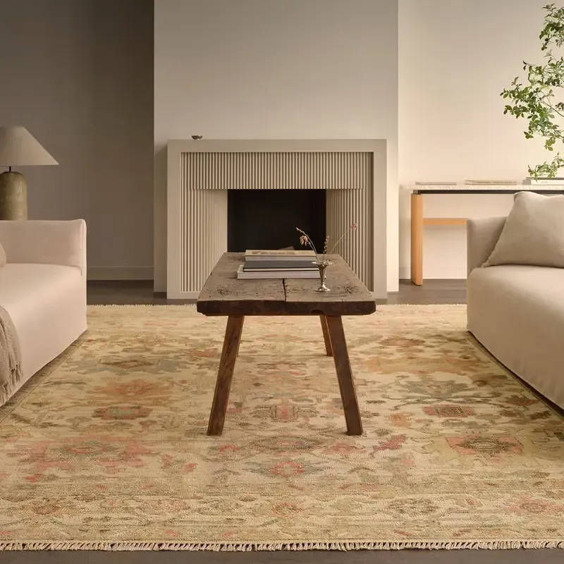 A living room with a fireplace , couch , table and rug