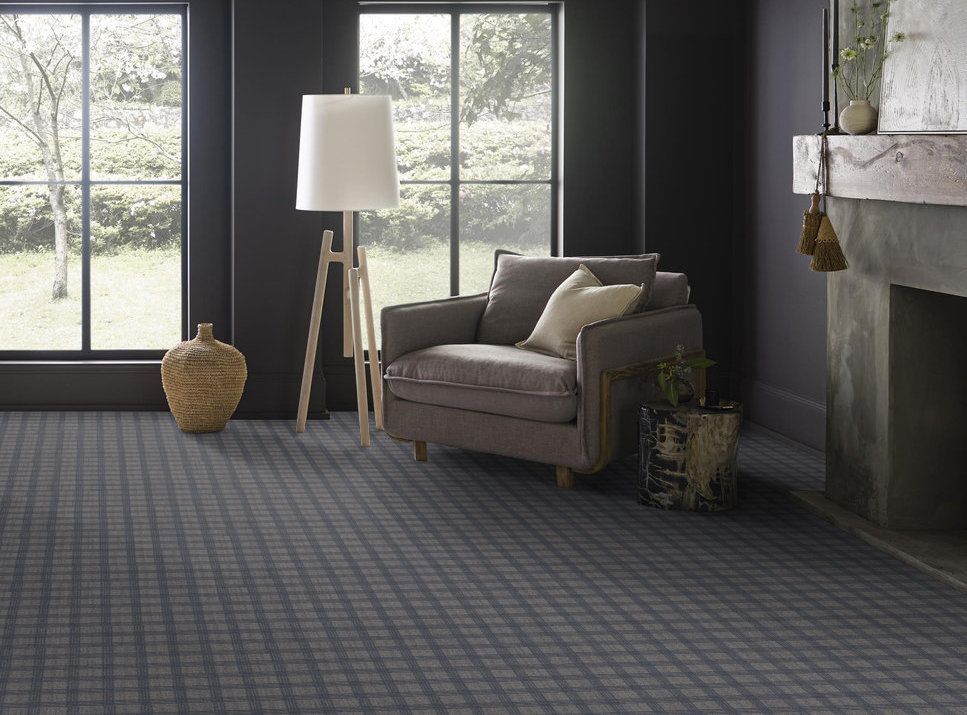 A living room with a chair , lamp , and fireplace.