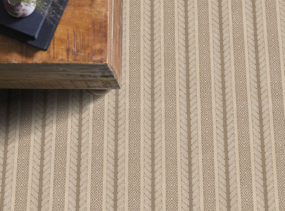 A coffee table is sitting on top of a striped rug.