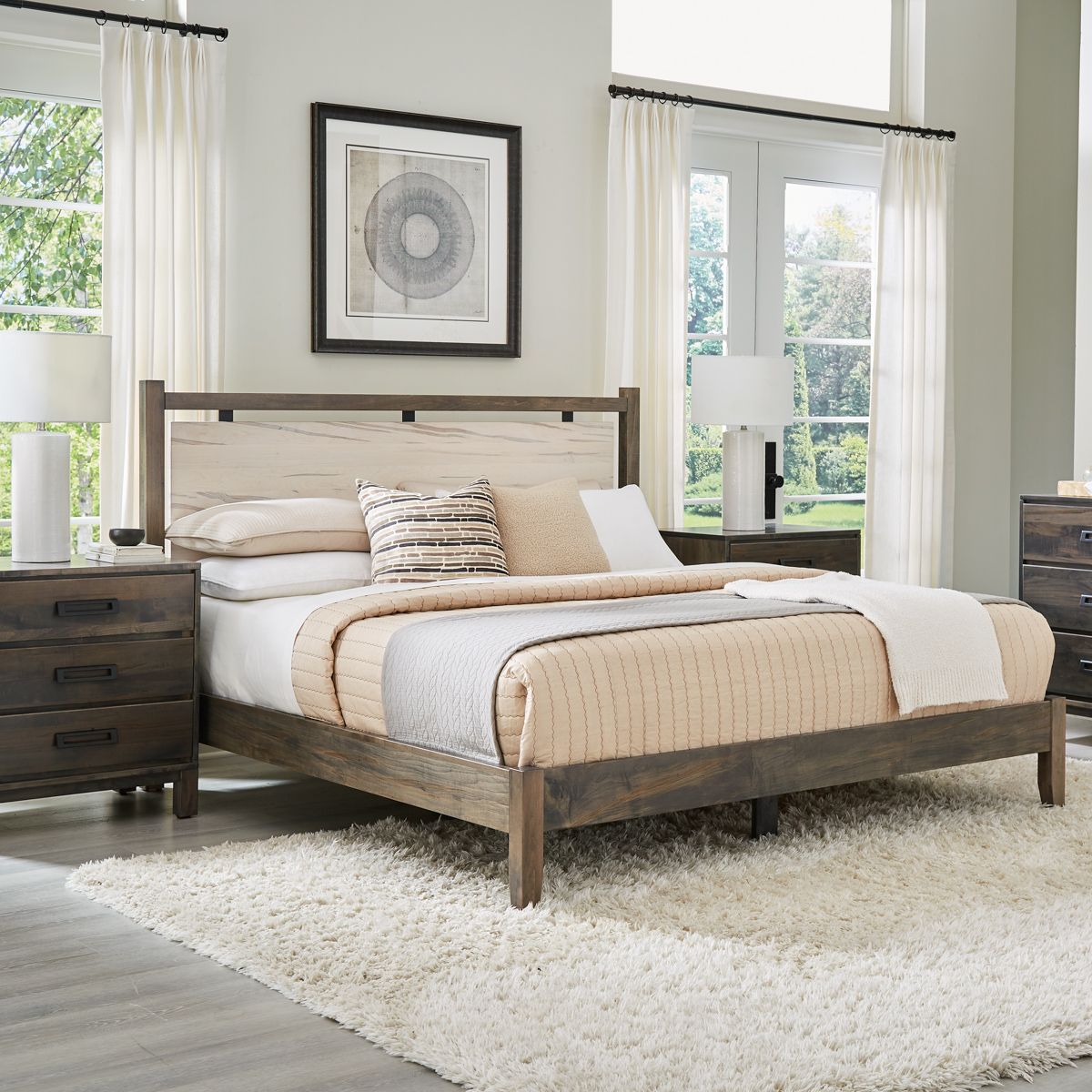 A bedroom with a bed , dresser , nightstand and rug.