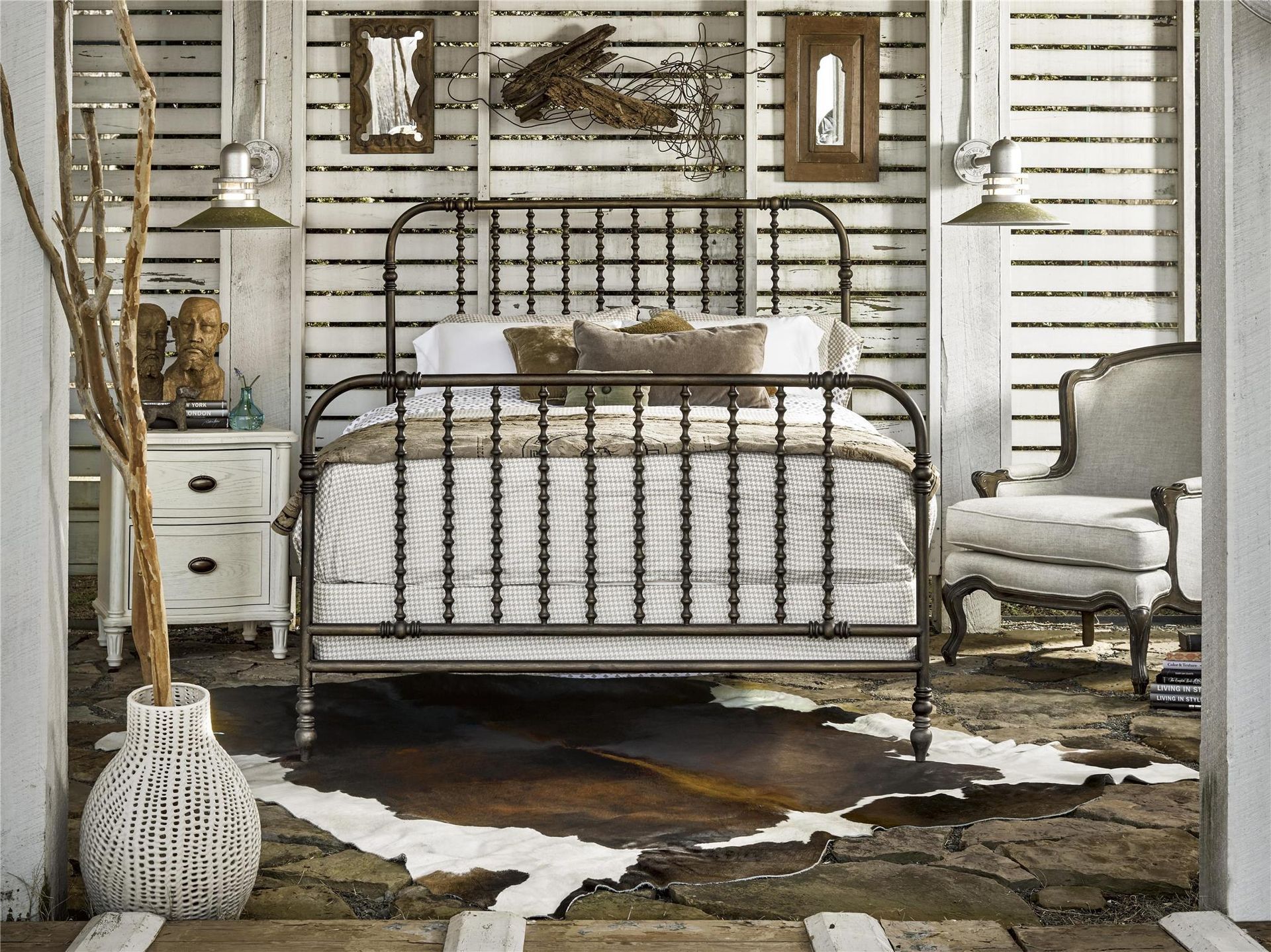 A bedroom with a bed and a cowhide rug