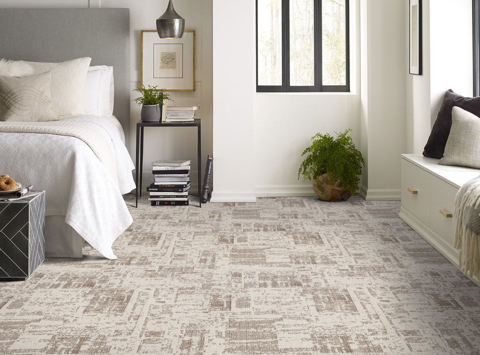 A bedroom with a bed , couch , window and carpeted floor.