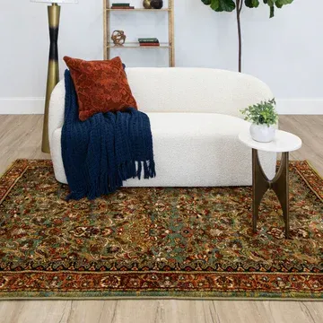 A living room with a couch and a rug on the floor.