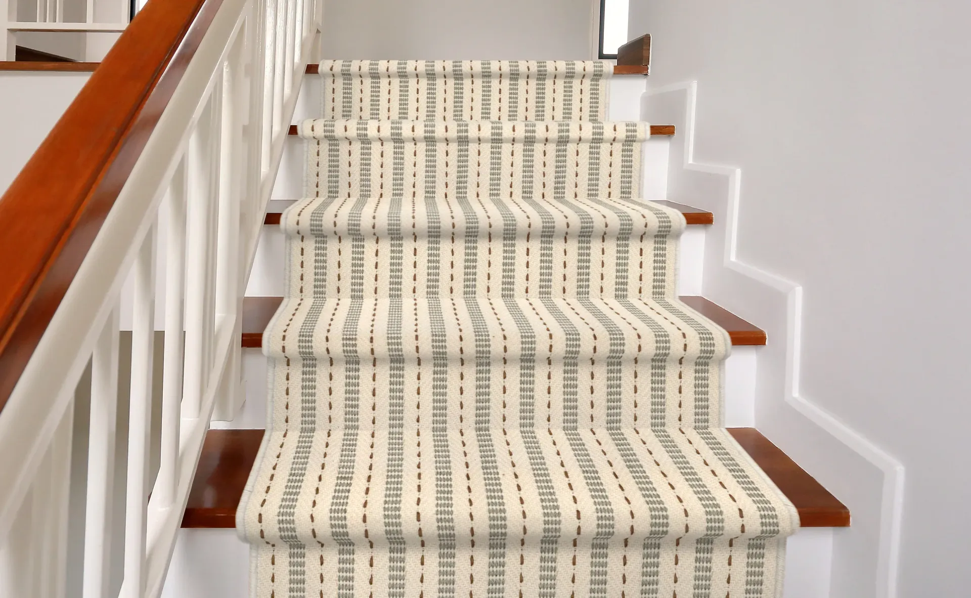 A staircase with a carpet on the steps and a wooden railing.