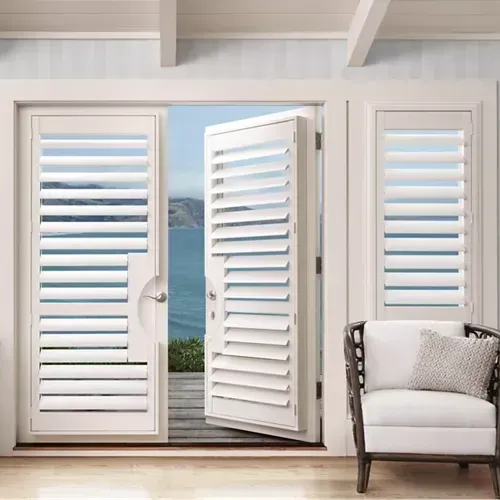 A living room with a chair and a view of the ocean.