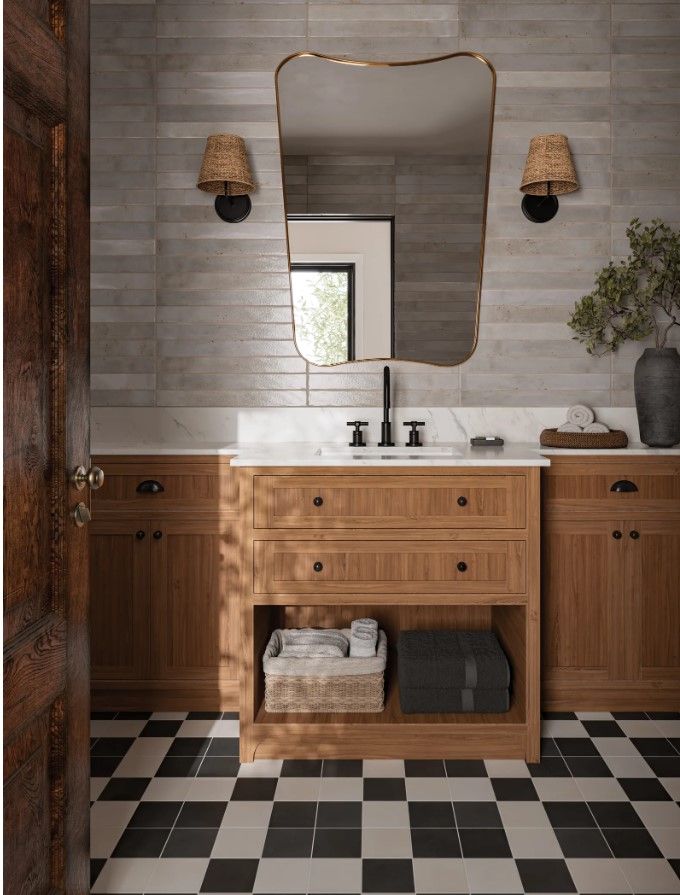 A bathroom with two sinks , a mirror , and a checkered floor.