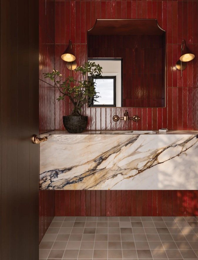 A bathroom with red tiles and a marble sink.