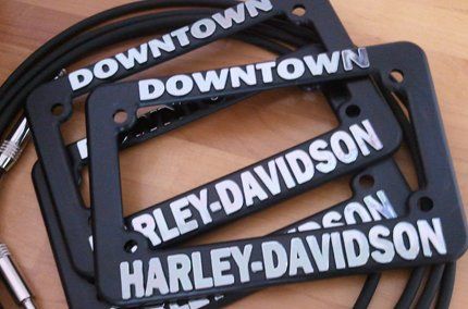 Three harley davidson license plates are stacked on top of each other