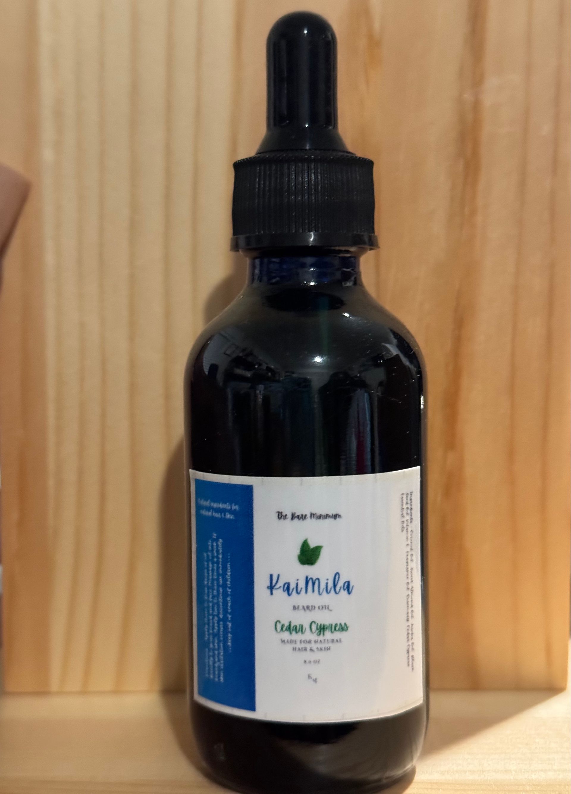 Dark blue bottle of Famila herbal tincture with dropper on wooden shelf.