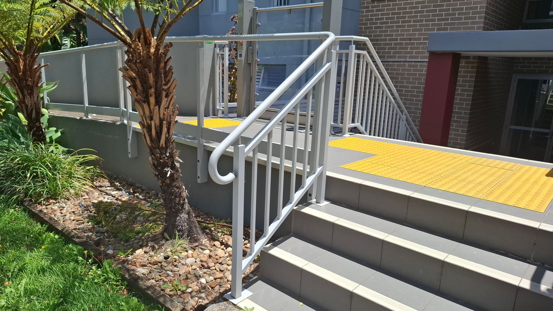 Staircase with handrail leading to a yellow tactile paving platform - Sydney, NSW - Alta Trading Pty Ltd Staircase with handrail leading to a yellow tactile paving platform - Sydney, NSW - Alta Trading Pty Ltd