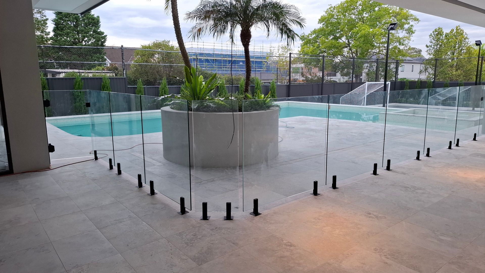 Two construction workers are pouring concrete on a concrete slab.