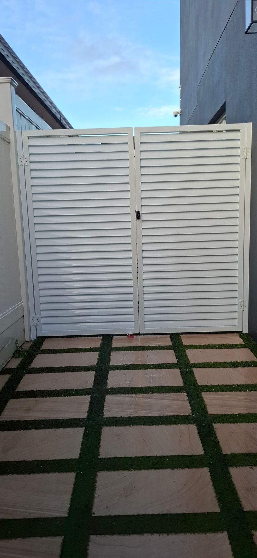 White slatted gate on a brick walkway with artificial grass in between - Sydney, NSW - Alta Trading Pty Ltd