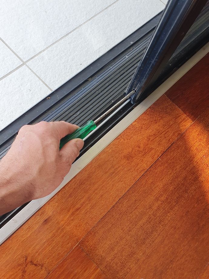 Worker Repairing Window With Screwdriver Indoors — B&A Doors In Mermaid Waters Queensland