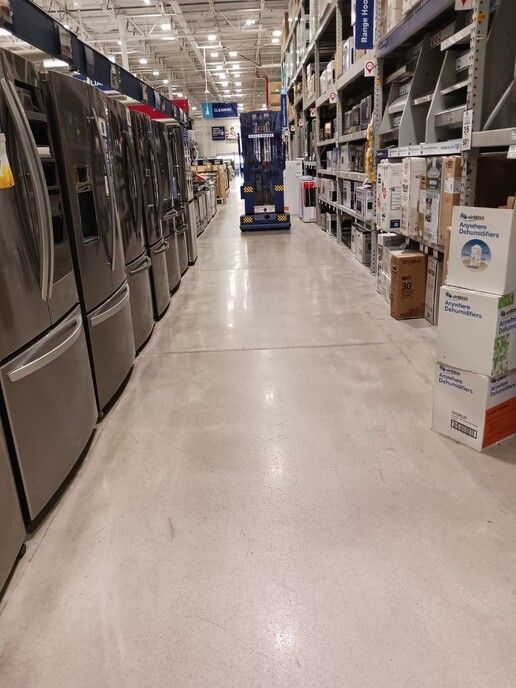 A row of refrigerators are lined up in a store.
