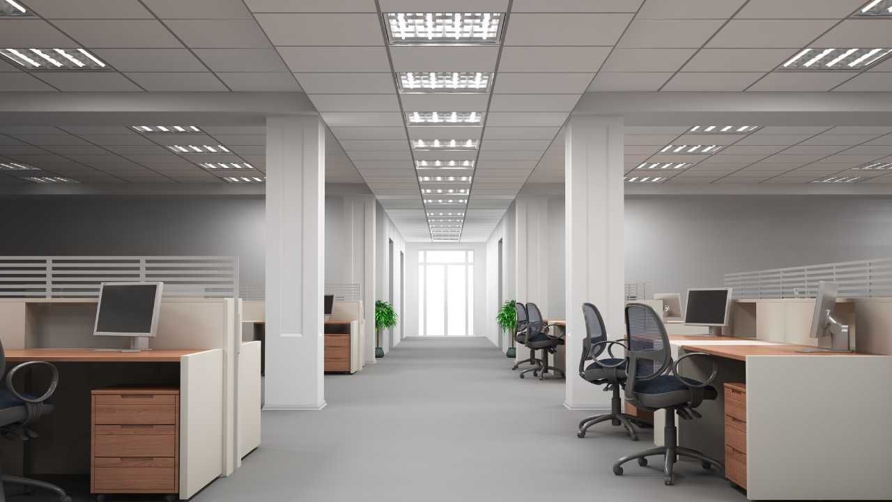 Interior of spacious office with rows of desks and chairs neatly arranged.