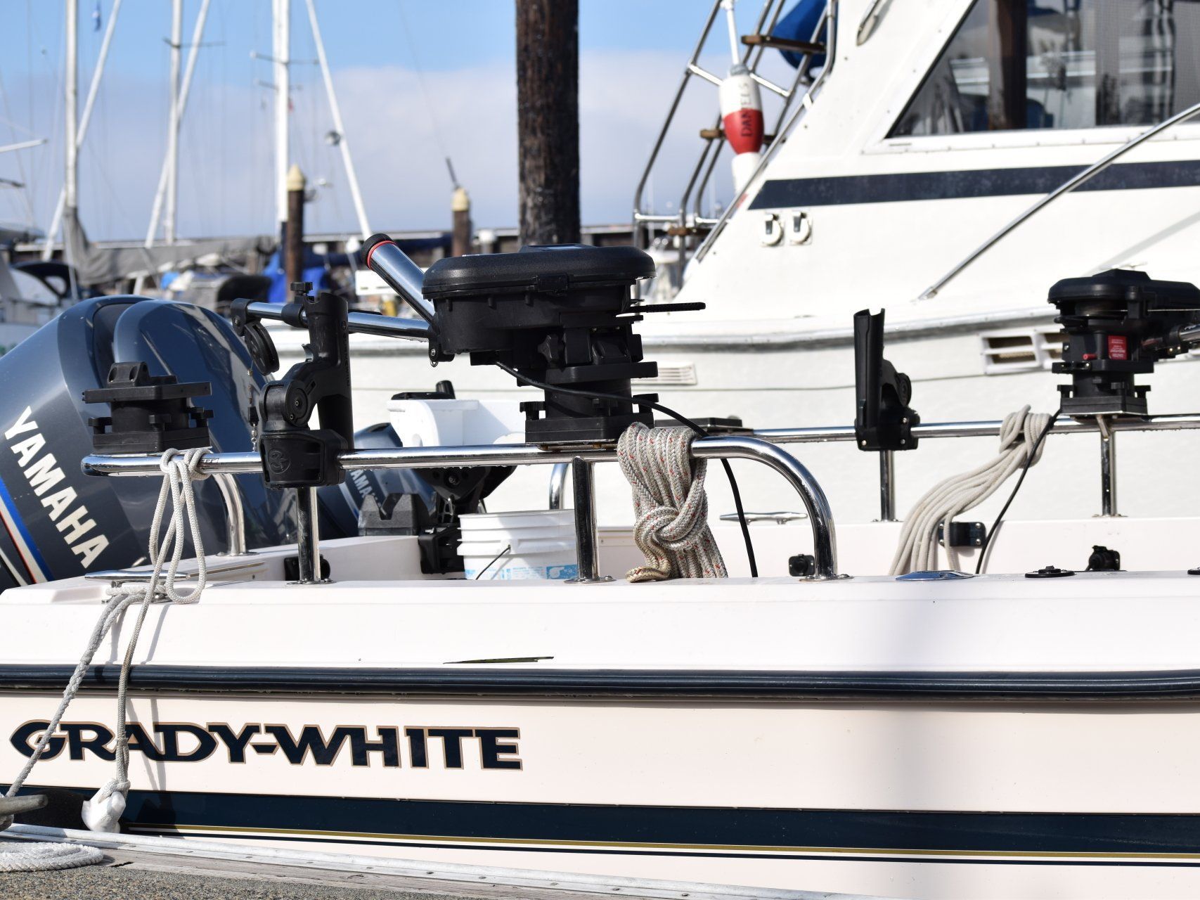 A Grady White boat with a yamaha engine and Tanner Manufacturing rails is docked at a marina.