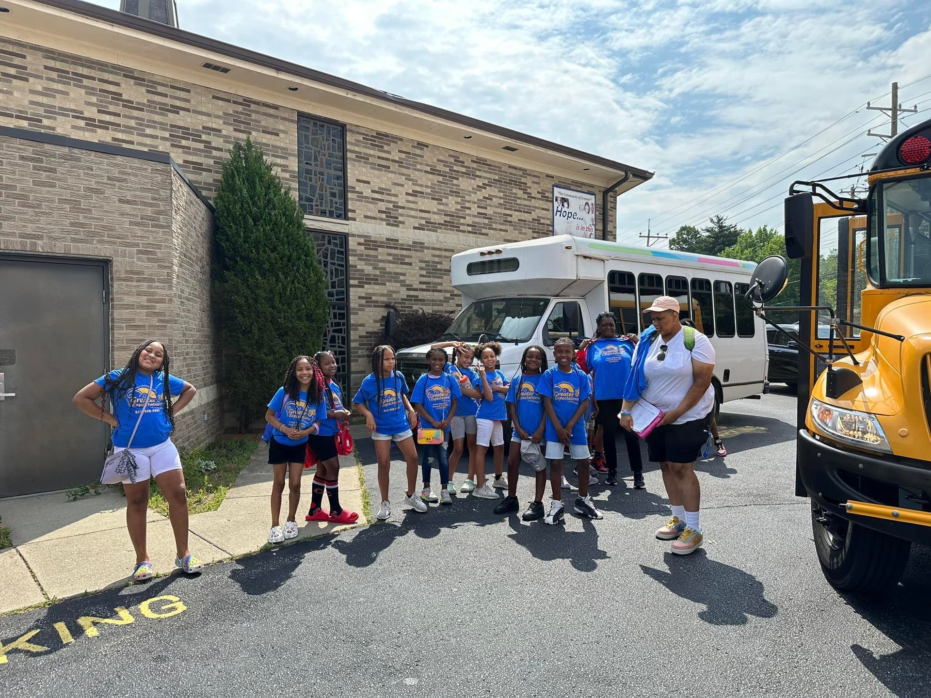 A group of children are standing in front of a school bus.