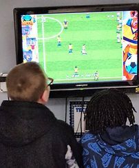 Two people are sitting in front of a television playing a video game.