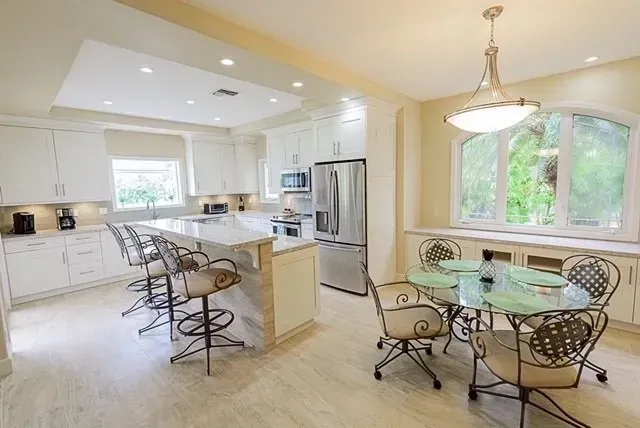 A kitchen with a table and chairs and a refrigerator.